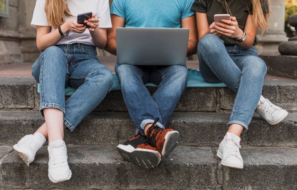 teens-sitting-stairs-working-phones-laptop